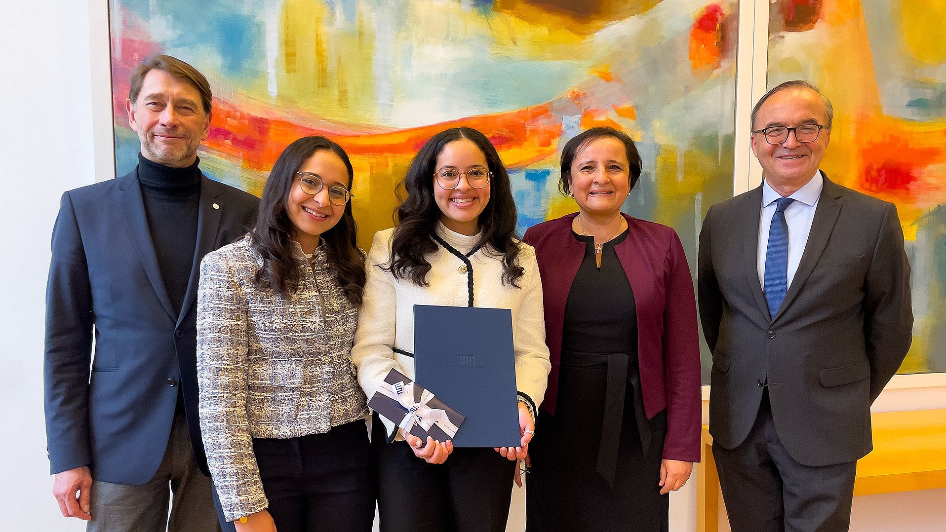 Gruppenfoto von DAAD-Preisträgerin Nadine Abdelmalek (Mitte) mit Dr. Stephan Geifes (links) und Prof. Gerhard Müller (rechts) sowie ihrer Schwester (2. v.l.) und ihrer Mutter (2. v.r.)