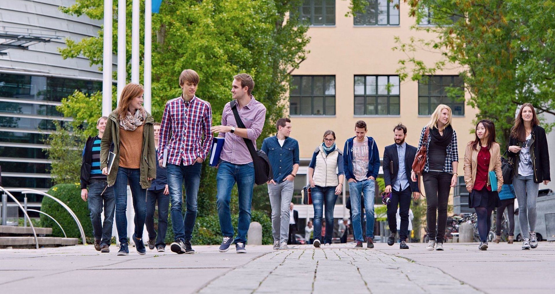 Stipendiat:innen des Deutschlandstipendiums gehen als Gruppe über den Innenhof der TUM am Stammgelände des Münchner Innenstadt-Campus.