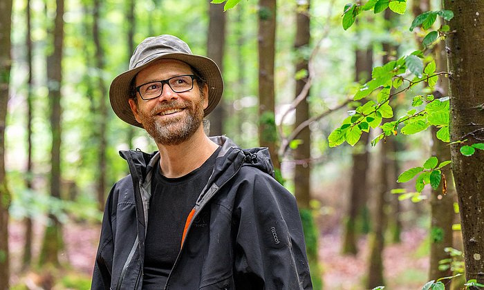 Prof. Rupert Seidl doing research in a forest. 