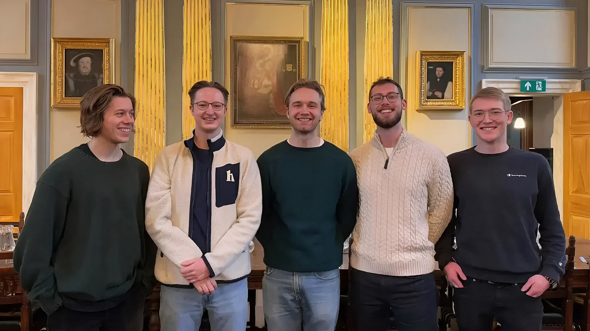 Group photo of the five founders of wahl.chat Sebastian Maier, Anton Wyrowski, Michel Schimpf, Robin Frasch and Roman Mayr, standing in a prestigious room in front of golden columns and paintings on the walls
