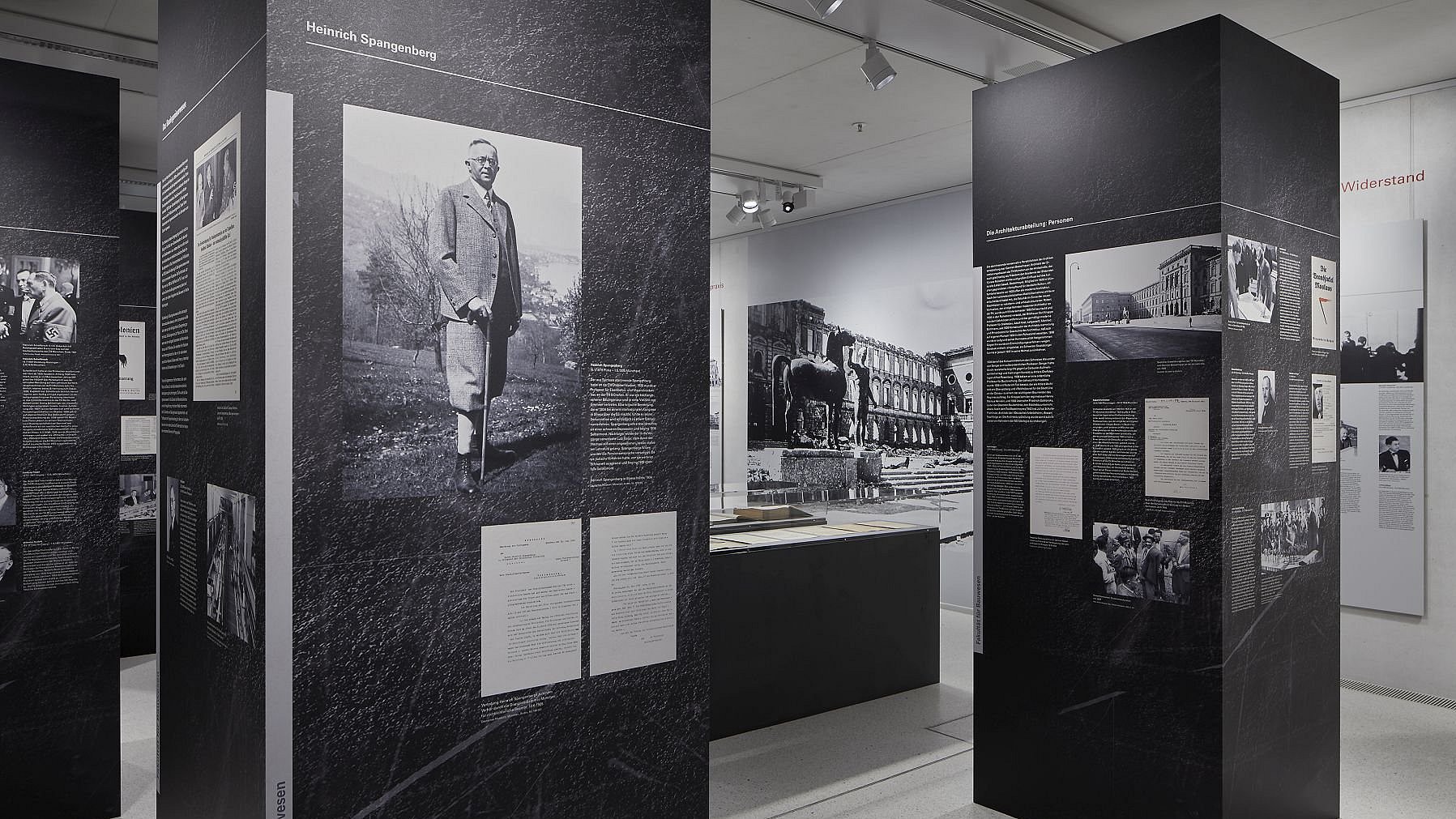 Ausstellungsraum der Sonderausstellung über die Geschichte der Technischen Hochschule München (heute Technische Universität) in der NS-Zeit im NS-Dokumentationszentrum München. Zu sehen sind Schwarz-Weiß-Fotografien und Infotexte.