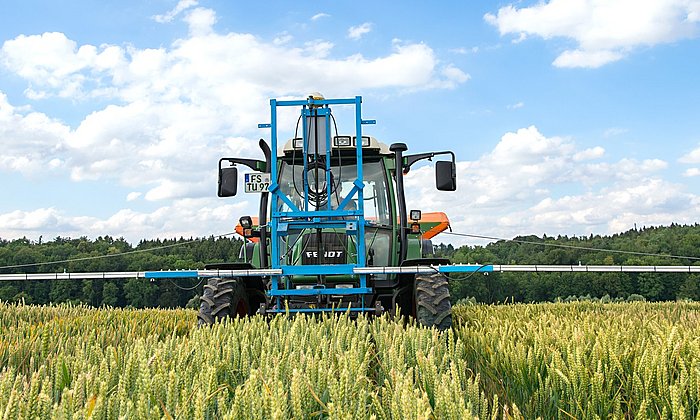 Tractor in grain field with front mounted device with sensors.
