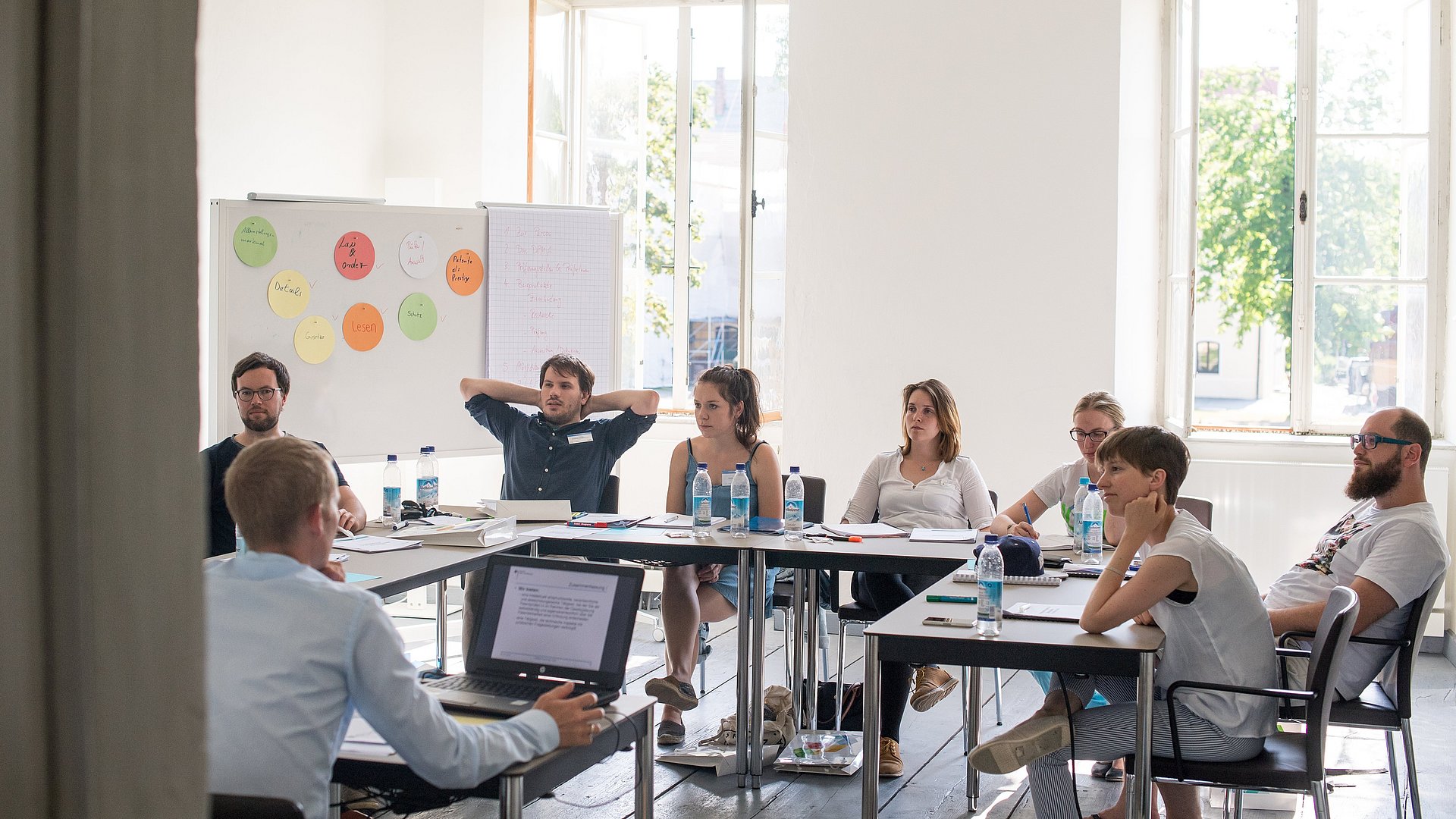 Personen brainstormen in einem Seminarraum.