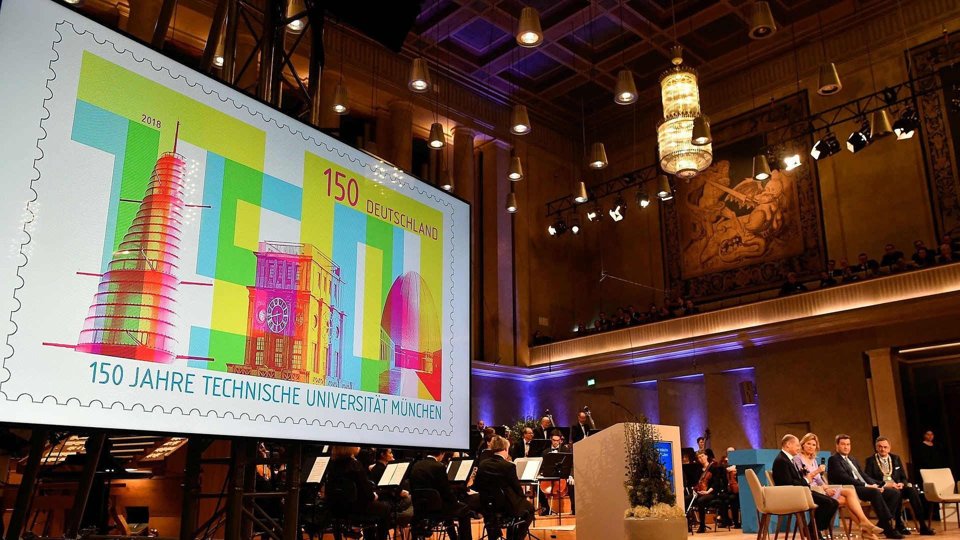 Screen presentation of the stamp produced to mark the 150th anniversary of the Technical University of Munich. The presentation took place in 2018 during a ceremony in the Hercules Hall of the Munich Residence.