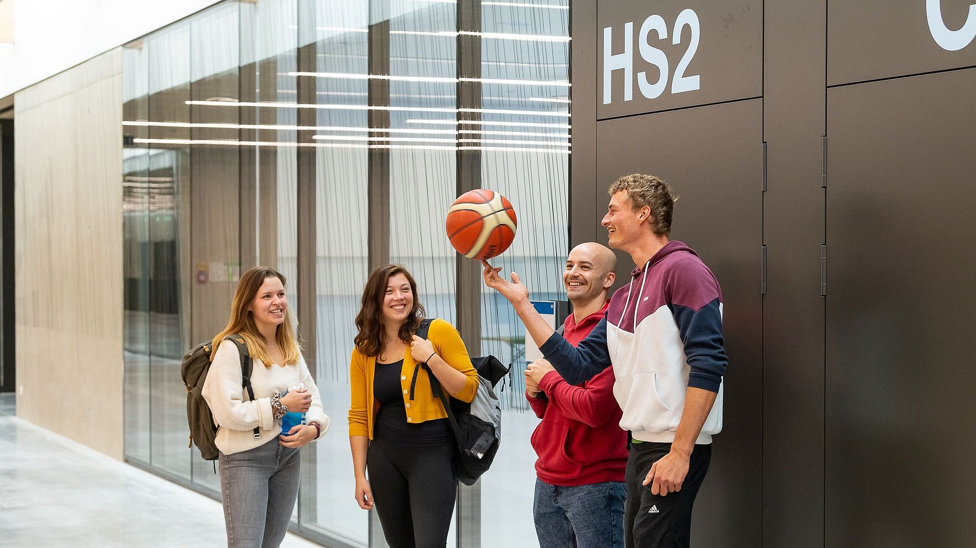 Students stand in a group and play with a ball