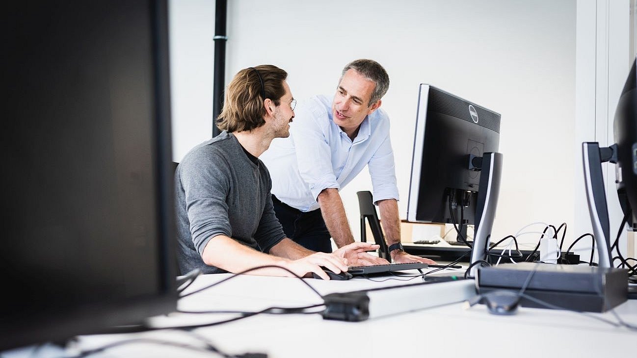 Daniel Rückert, Professor of AI in Healthcare and Medicine at TUM is discussing research results with a staff member.