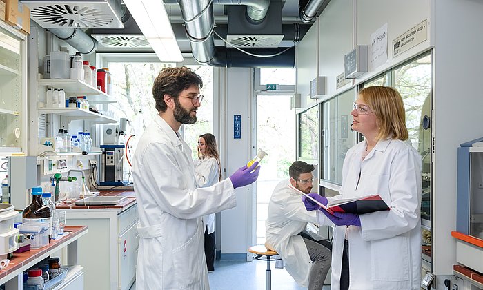 Dr. Guillaume Médard vom Lehrstuhl fuer Proteomik und Bioanalytik im Labor mit seiner Forschungsgruppe bei einer Besprechung.