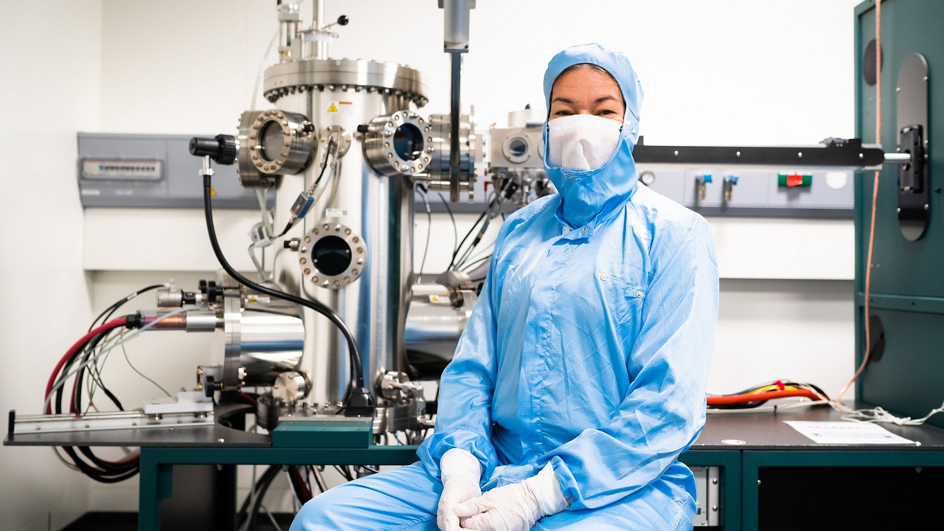 Eva Weig in front of the machine used to evaporate different metallic layers onto the chips via vapor deposition under ultrahigh vacuum. 