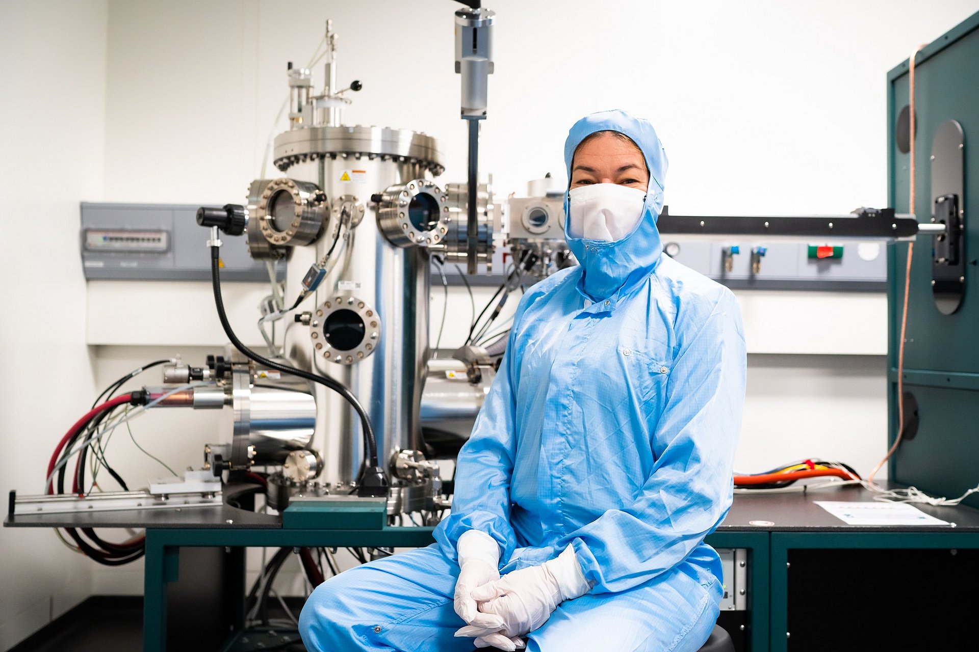 Die Professorin Eva Weig vor der Apparatur zum Aufdampfen der verschiedenen metallischen Schichten auf die Chips.