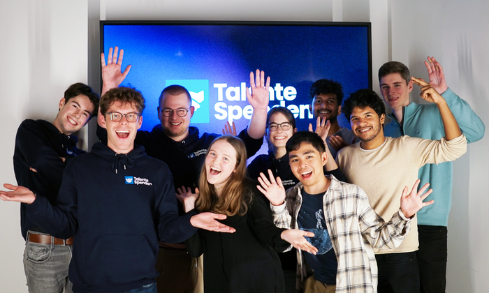 A group of students in front of the Talente Spenden e.V. logo
