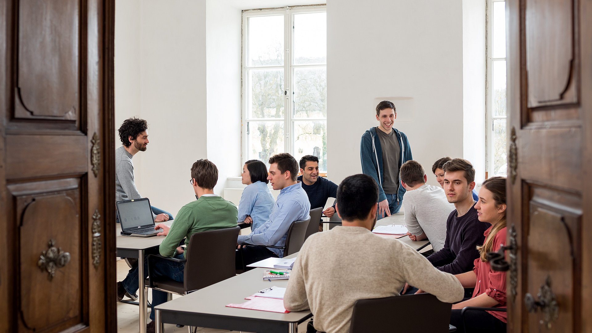 Studierende sitzen in einem Raum der Akademie.