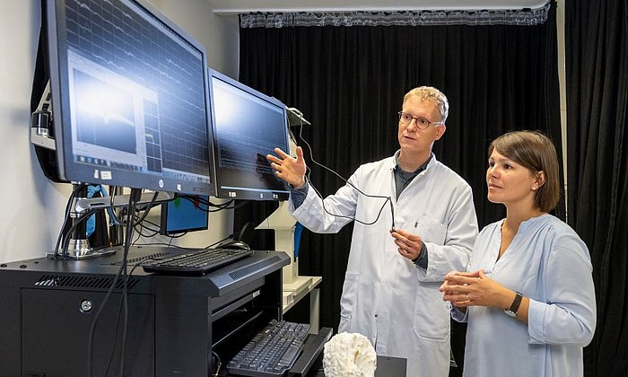 Prof. Julijana Gjorgijeva and Prof. Simon Jacob talk to each other in front of computer screens.