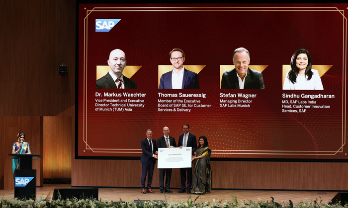 Representatives of SAP and TUM jointly present a large sheet of paper symbolizing increased cooperation.