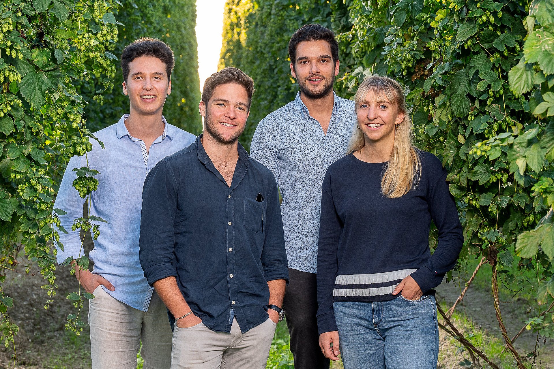 Das HopfON-Team steht zwischen den Hopfenreben im Feld