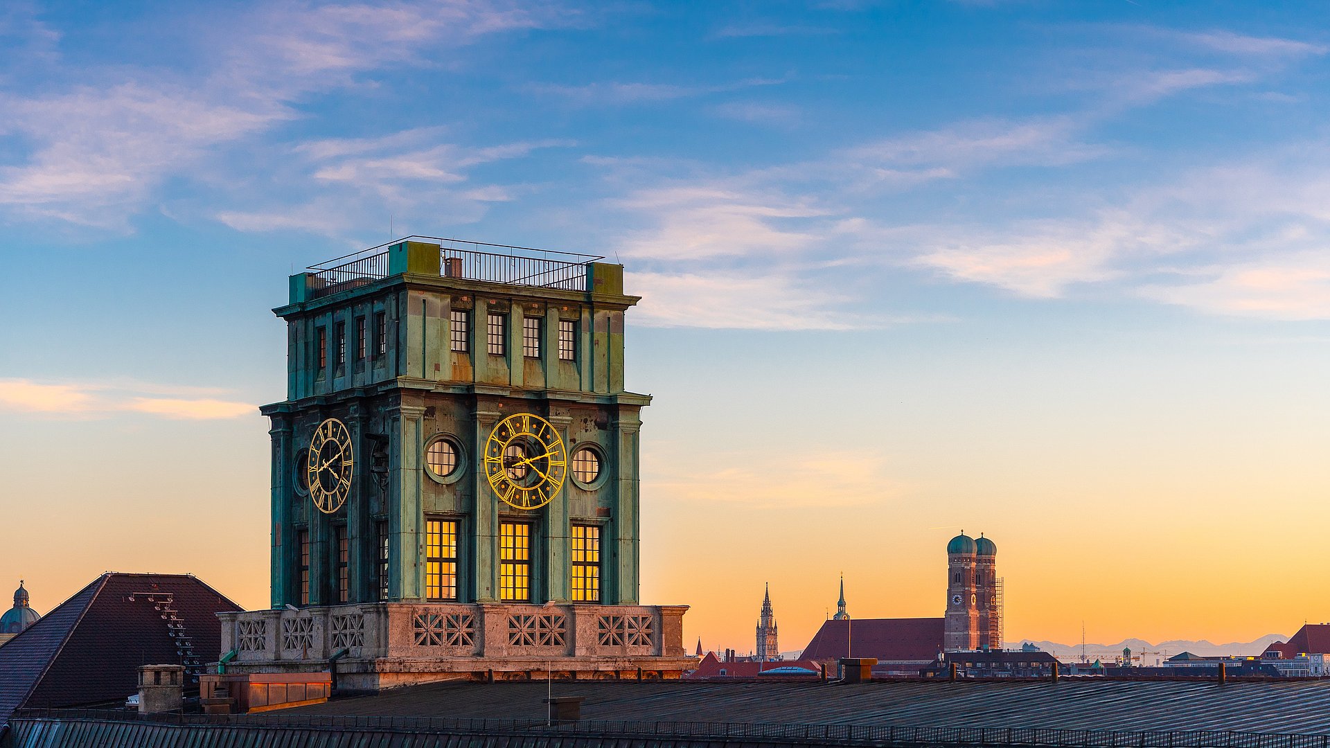 The skyline of downtown Munich at sunset. In focus is the Thiersch Tower, a bell tower and the landmark of the TUM.
